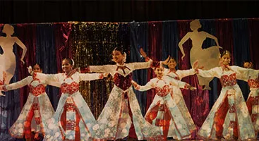 Dancers in vibrant red costumes mid-performance